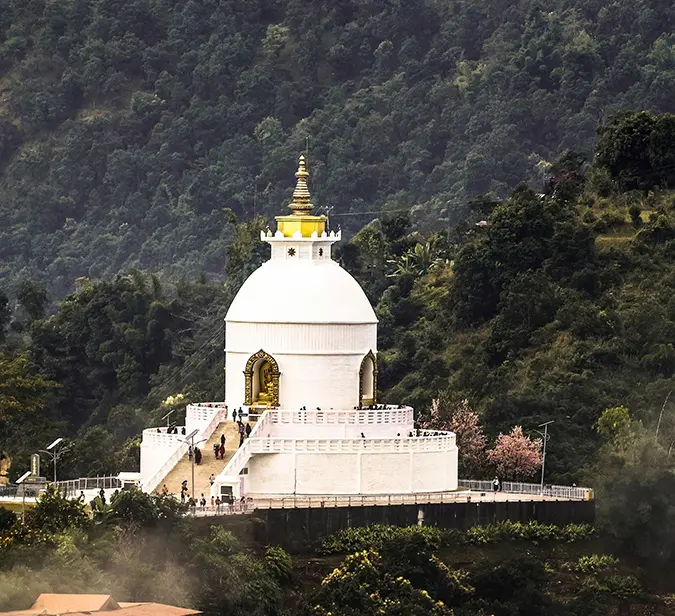 World Peace Pagoda in Pokhara, Nepal surrounded by forested hills.