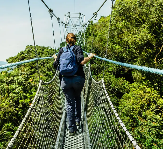 A hiker on forest canopy bridge in Rwanda’s biodiverse Nyungwe Forest National Park.