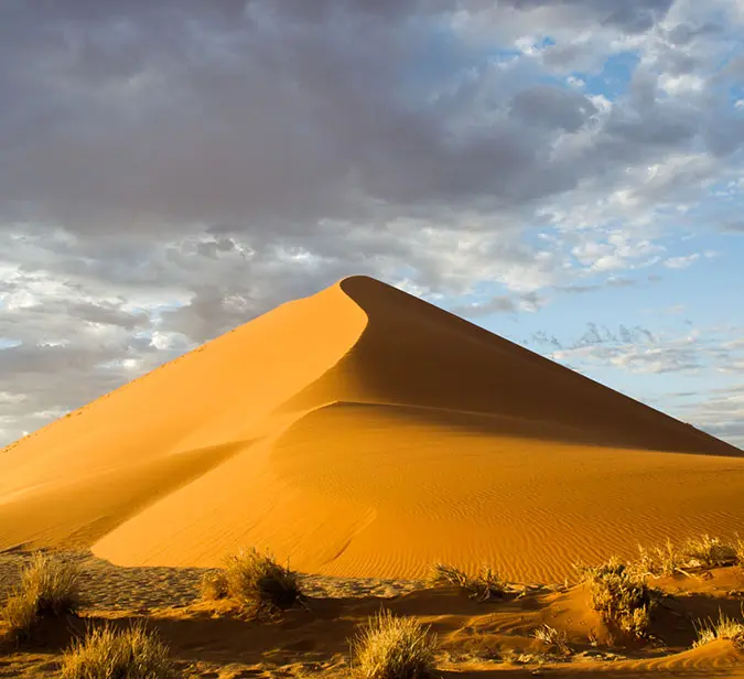 Sunlit sand dune with rippled texture in Sossusvlei, Namibia.