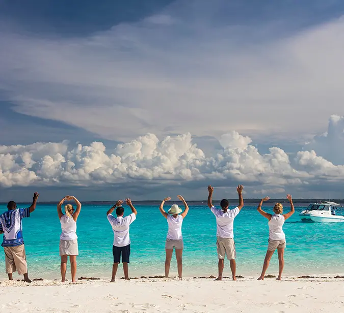 Farewell on the beach of Mnema Island with turquoise waters and blue sky in the background.