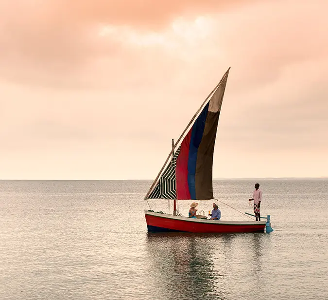Couple enjoying a sunset dhow cruise on calm waters near Benguerra Island.