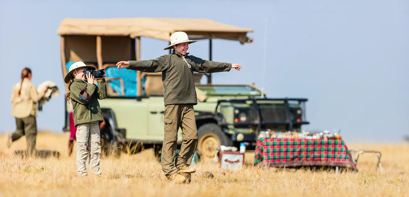 Young explorers on family safari in Phinda Private Game Reserve, capturing wildlife and fun moments.